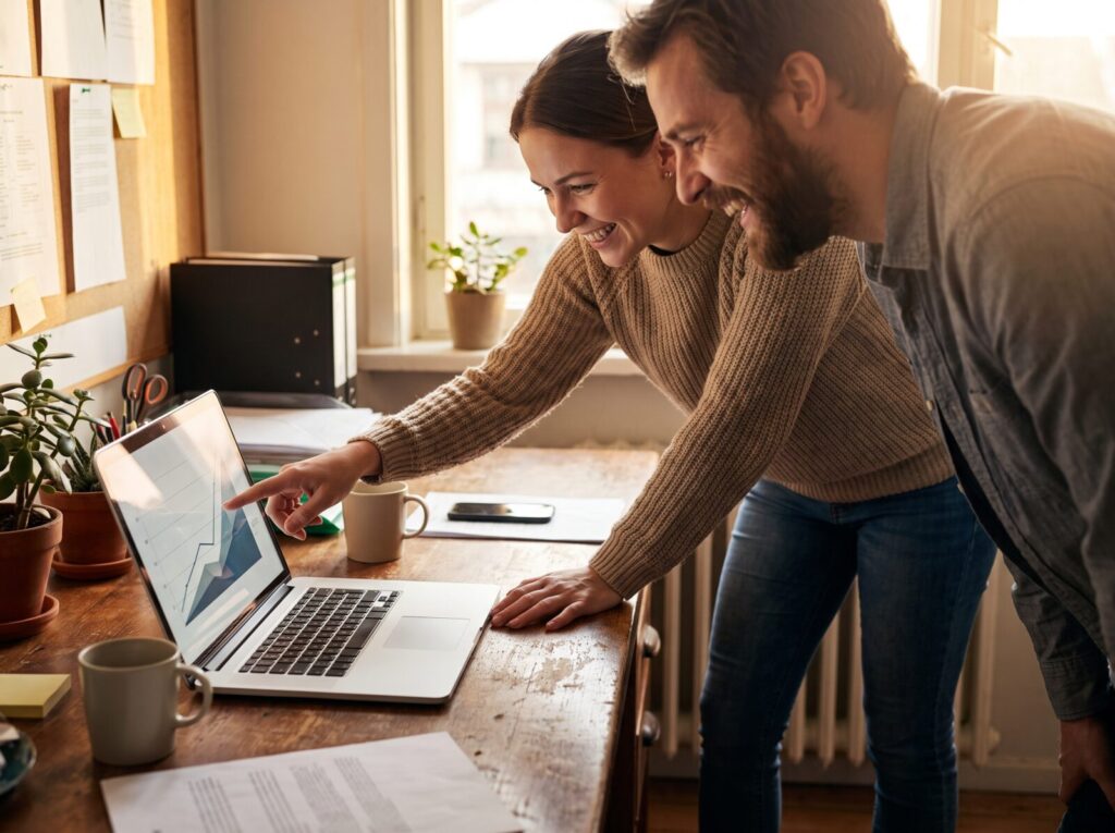 A client and consultant reviewing performance results together on a laptop.
